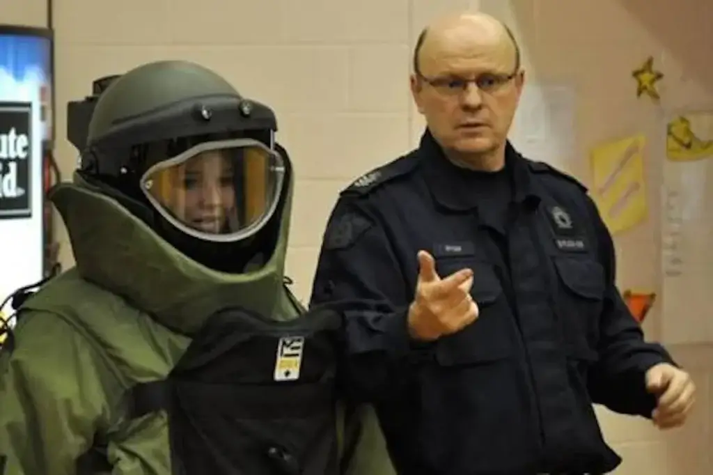 Sgt. Briggs gives direction to a technician wearing a Med-Eng Bomb Suit and helmet