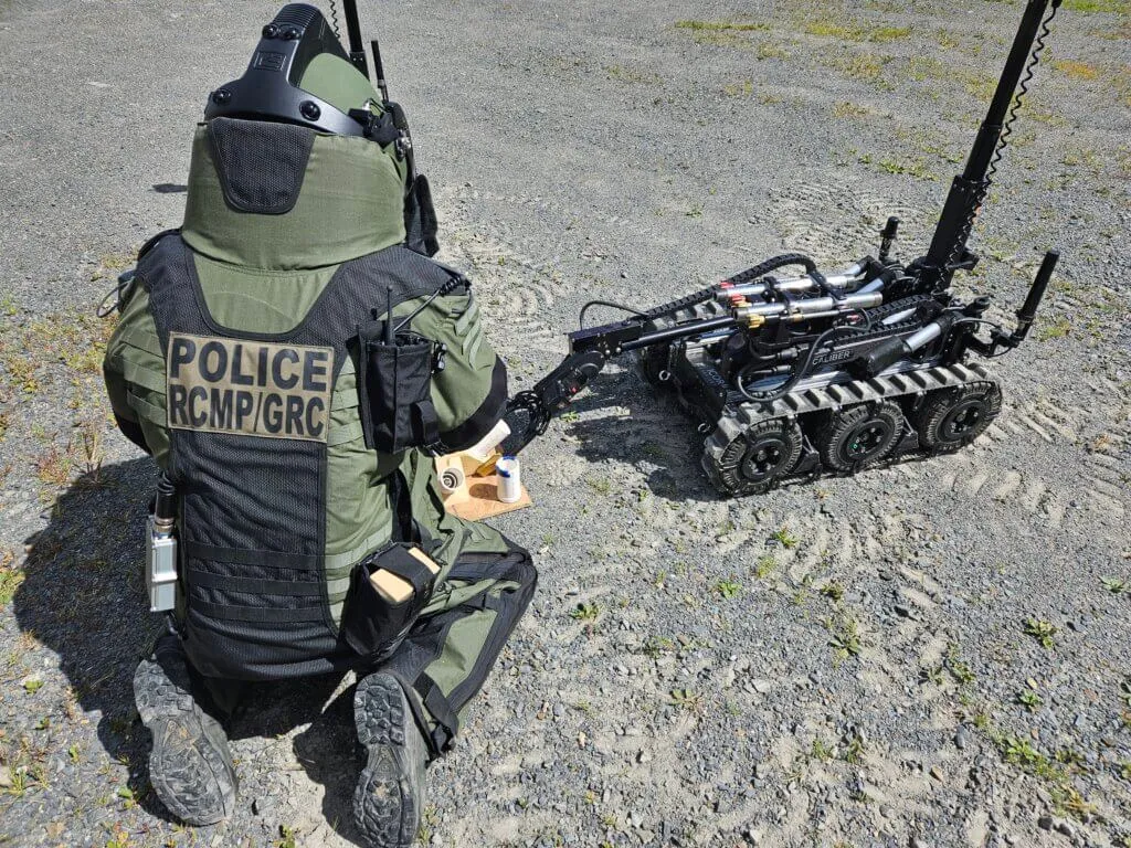 An RCMP Member from the EDU using a robot and wearing the Med-Eng EOD 10E Suit manufactured in Pembroke, Ontario.
